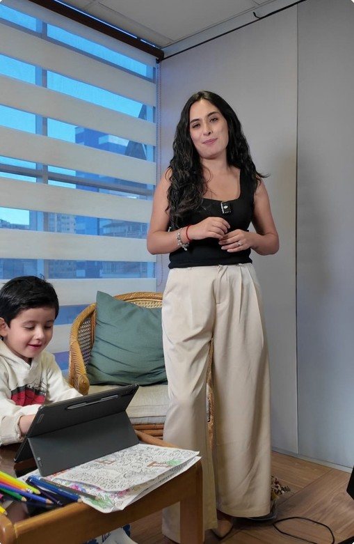 Educadora de Synavia junto a un niño que trabaja en su tablet